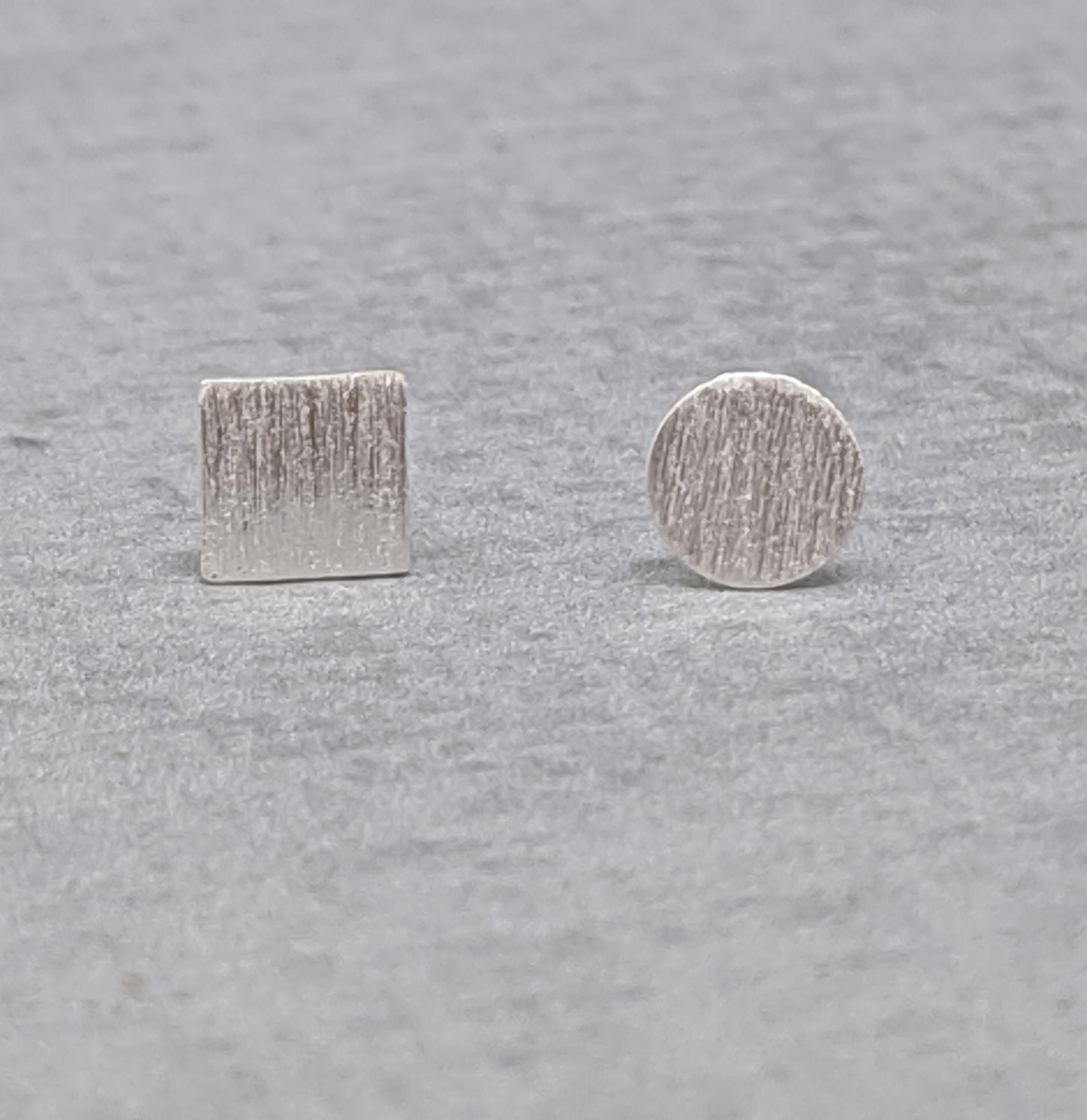 Mismatched square and round sterling silver studs with brushed finish